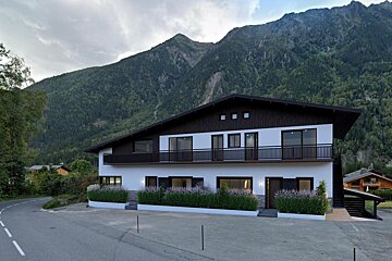A large house with a mountain in the background