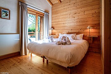 A bedroom with a bed and a picture on the wall