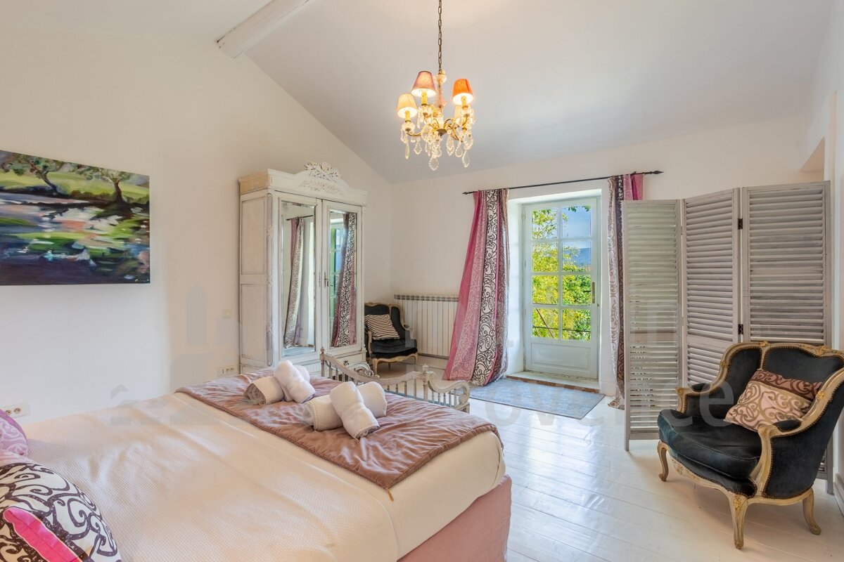 A bedroom with a painting on the wall above the bed