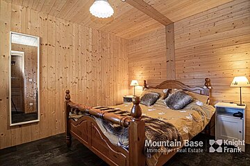 A bedroom with a bed and a sign that says mountain base immobilier real estate
