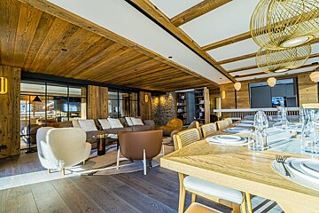 A dining room with a wooden table and chairs