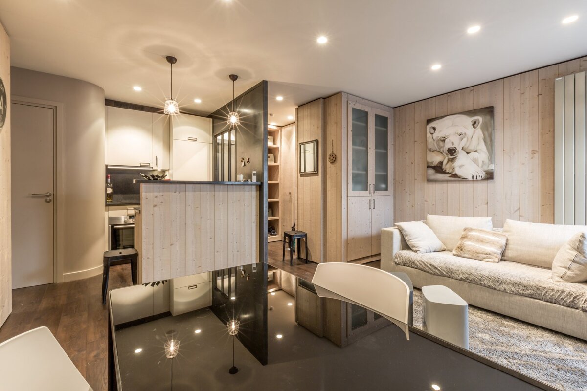 A living room with a table and chairs and a flat screen tv