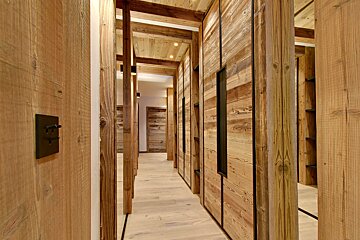 A wooden hallway with a light switch on the wall