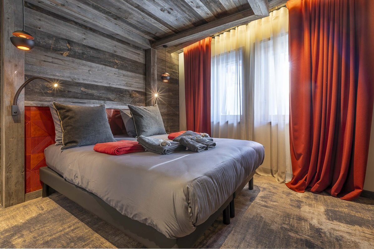 A bedroom with a large bed and red curtains
