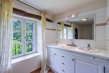 A bathroom with two sinks and a large mirror