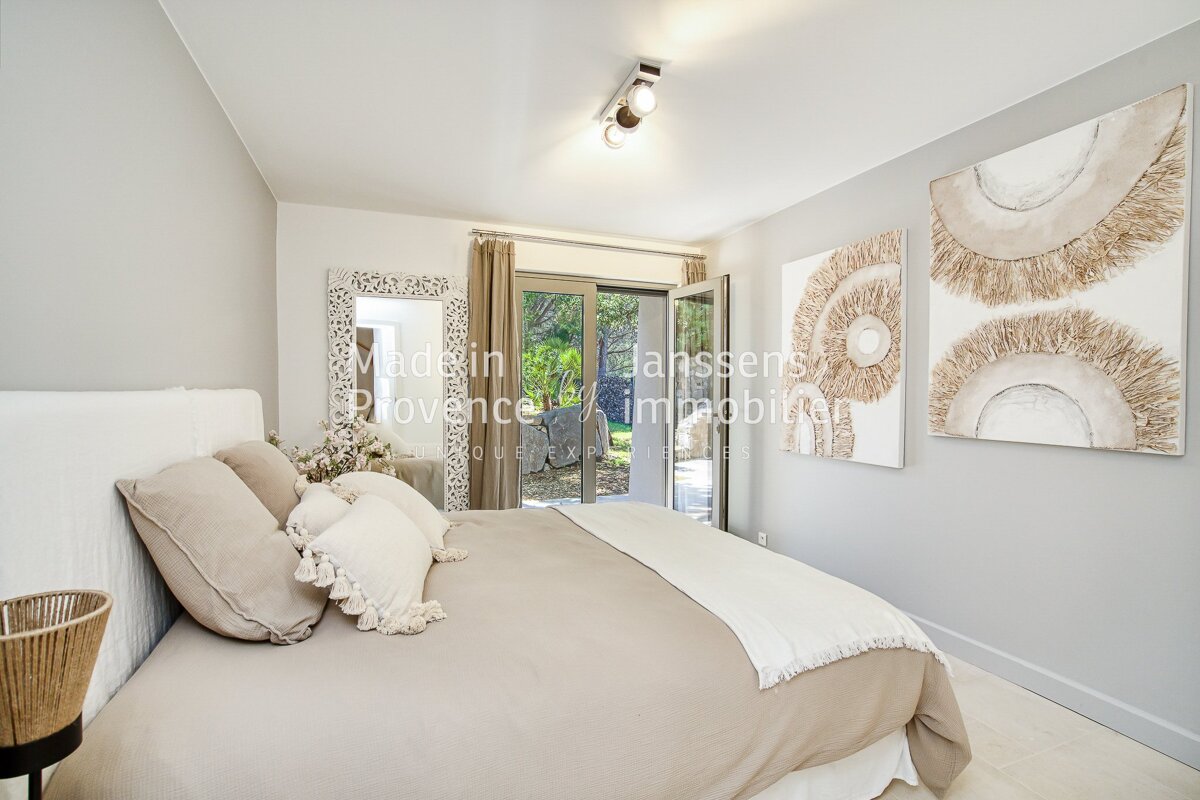 A bedroom with a large bed and a painting on the wall that says provence
