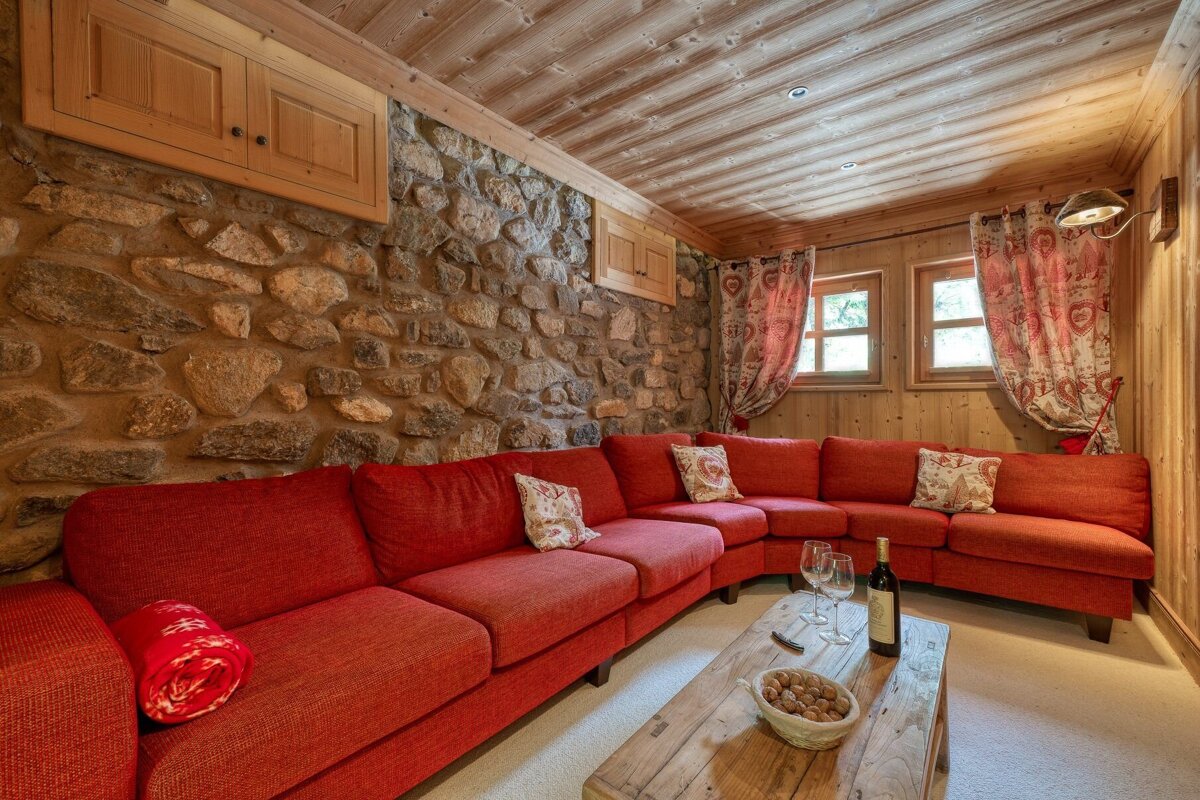 A bottle of wine sits on a wooden table in a living room