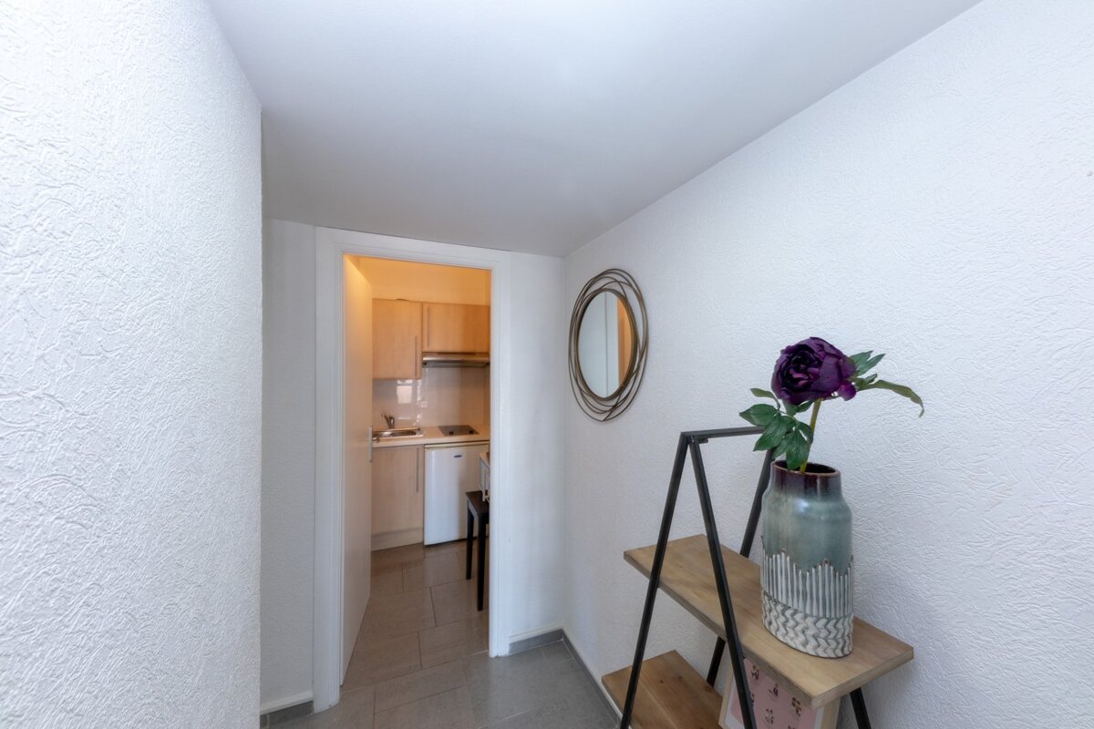 A vase of flowers sits on a shelf in a hallway