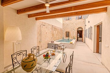 A dining area with a table and chairs and a swimming pool
