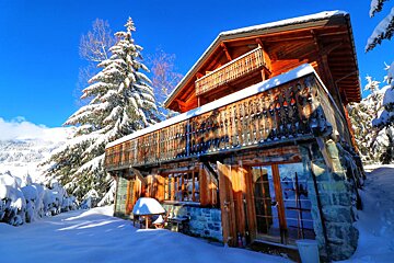 A snowy house with a blue sky in the background