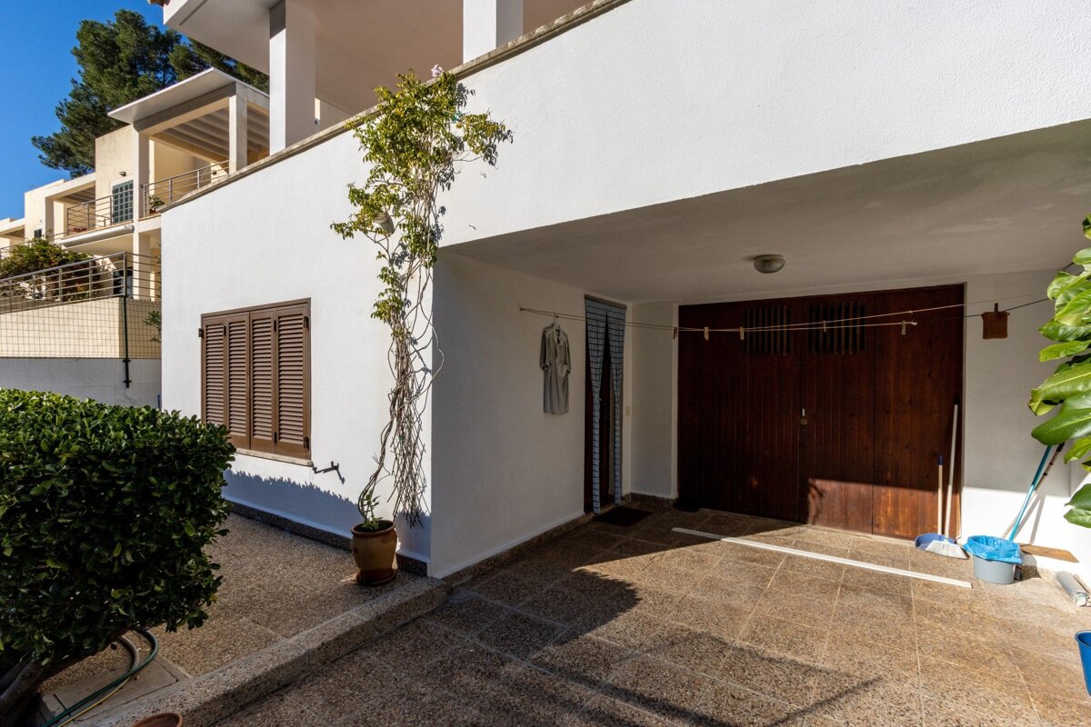 A white building with a wooden door and shutters