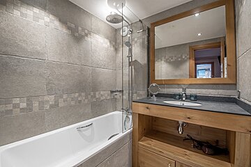 A bathroom with a bathtub a sink and a mirror