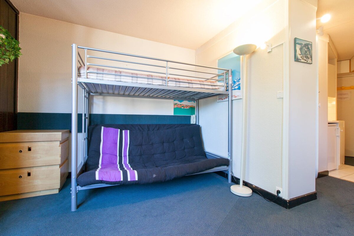A bunk bed with a futon underneath it