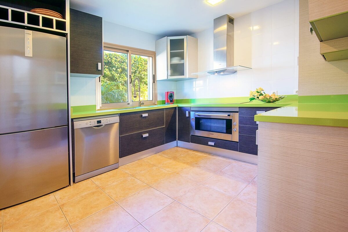 A kitchen with stainless steel appliances and green counter tops