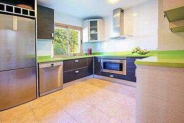 A kitchen with stainless steel appliances and green counter tops