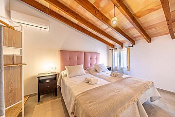 A bedroom with two beds and a wooden ceiling