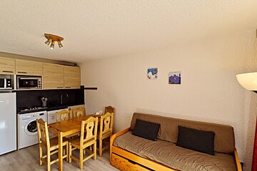 A kitchen with a table and chairs and a washing machine
