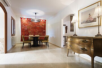 A dining room with a table and chairs and a dresser