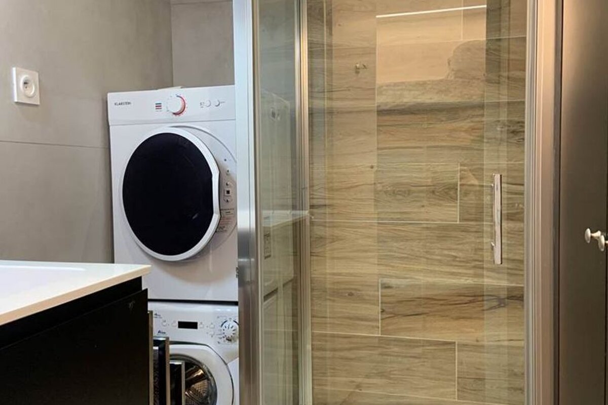 A klarton washer and dryer are stacked on top of each other in a bathroom