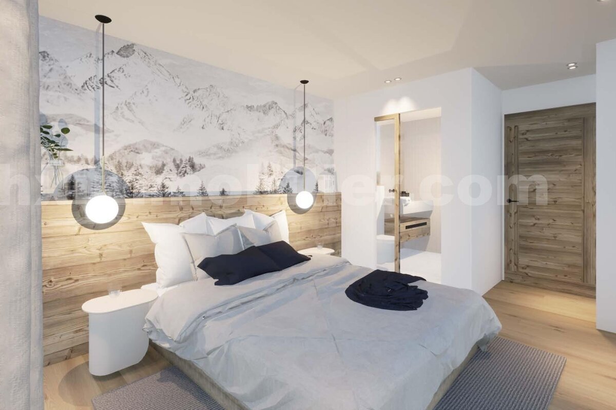 A modern bedroom with a snowy mountain mural, wooden headboard, white bedding, spherical pendant lights, and a partially visible ensuite.