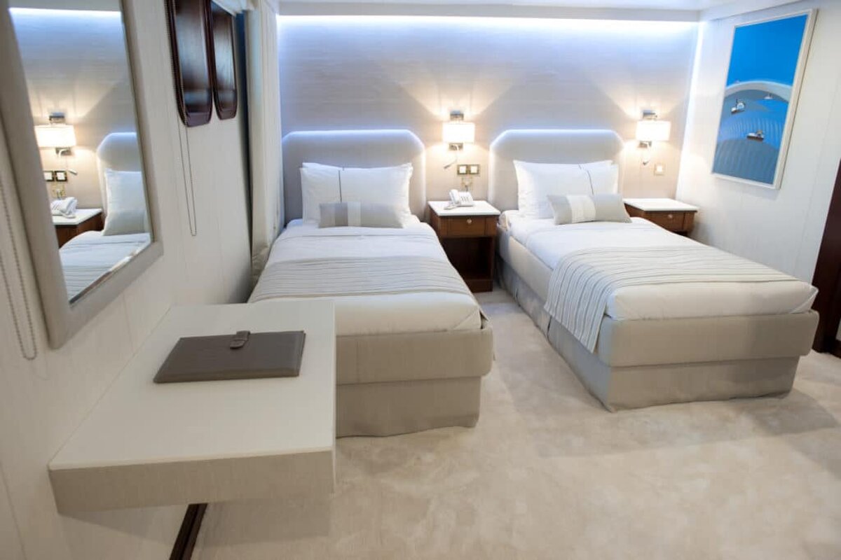 A hotel room with two beds and two nightstands