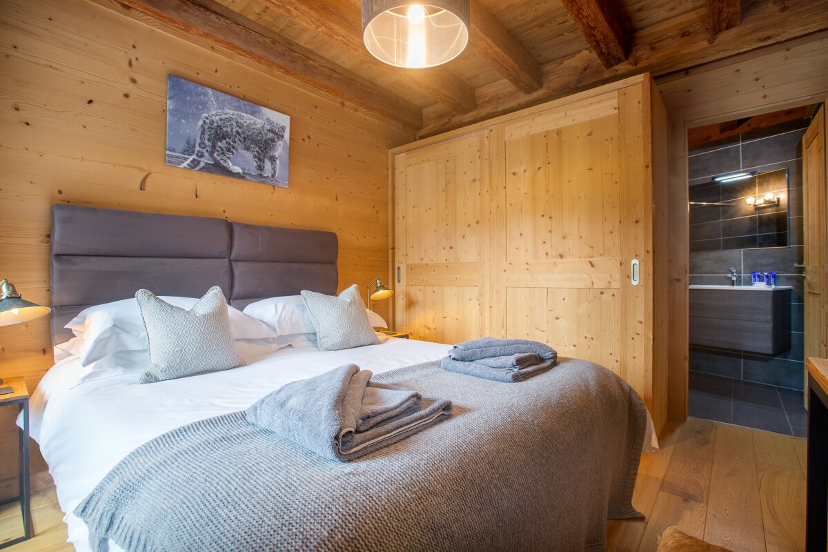 A bedroom with a bed and a picture of a leopard on the wall