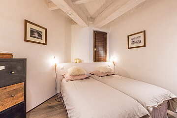 A bedroom with two beds and two framed pictures on the wall