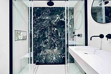 A bathroom with a black and white marble shower