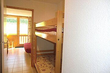 A room with bunk beds and a red couch