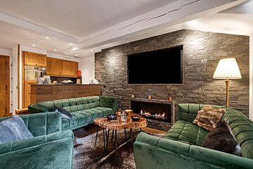 A living room with green furniture and a fireplace