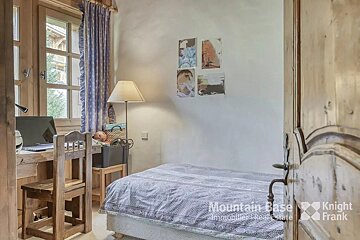A bedroom with a single bed and a desk with knight frank written on the door