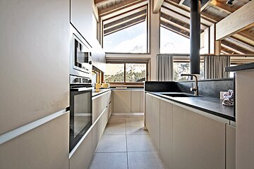 A kitchen with white cabinets and black counter tops