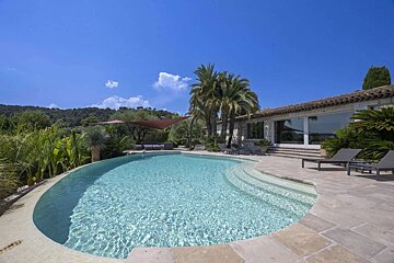 A large swimming pool in front of a house