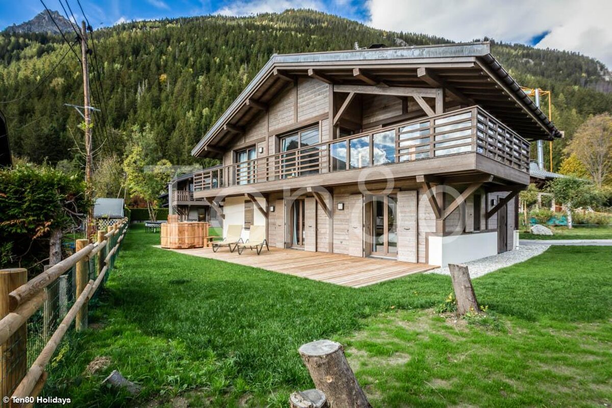A large wooden house with a fence in front of it