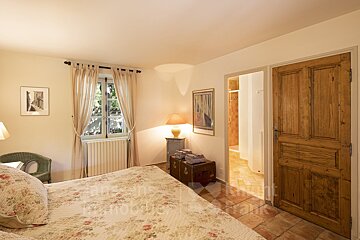 A bedroom with a large bed and a wooden door