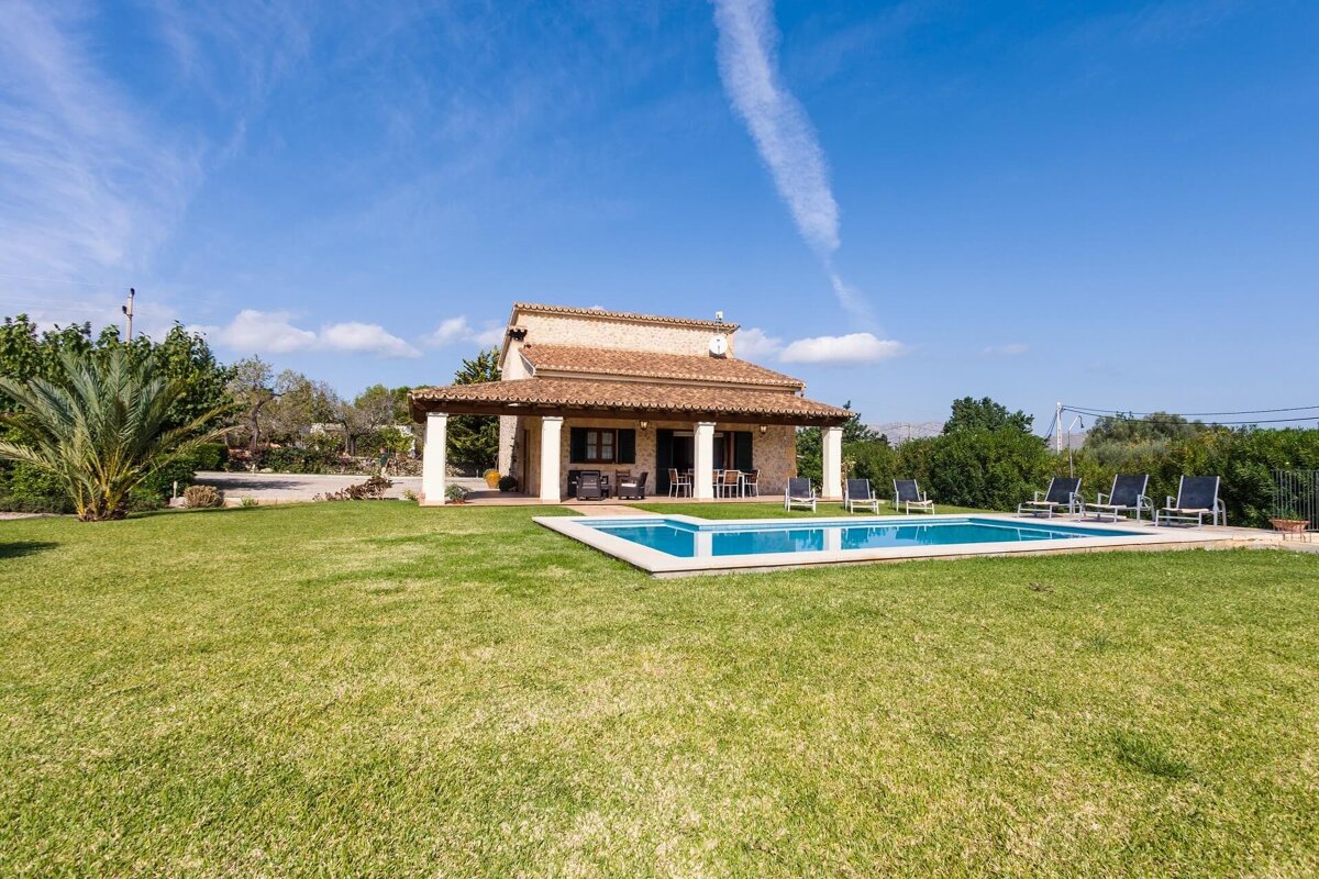 A house with a large swimming pool in front of it