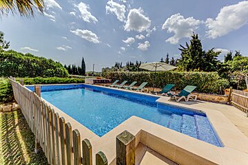 A large swimming pool surrounded by chairs and umbrellas
