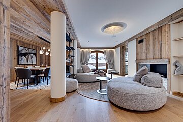 A living room with a round couch and a fireplace