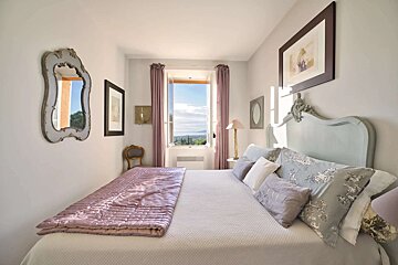 A bedroom with a bed and two mirrors on the wall