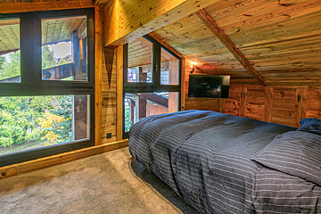 A bedroom with a bed and a flat screen tv