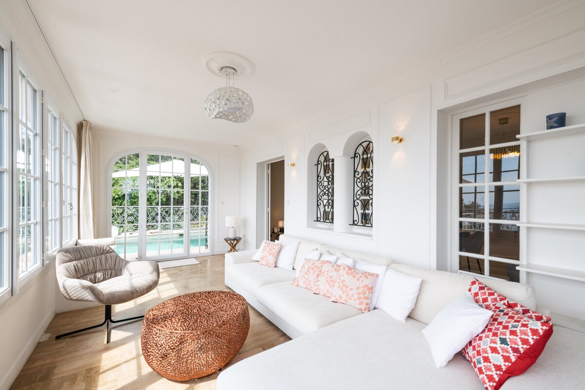A living room with a white couch and a chair
