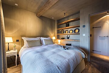A bedroom with a bed and shelves with mirrors on them
