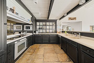 A kitchen with black cabinets and white counter tops