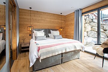 A bedroom with a large bed and a large window