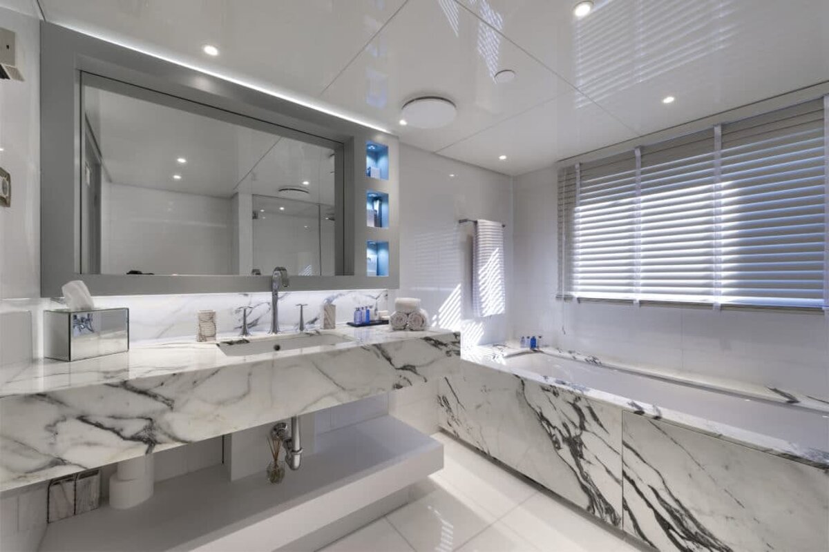 A bathroom with marble counter tops and a large mirror