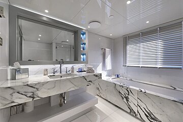 A bathroom with marble counter tops and a large mirror