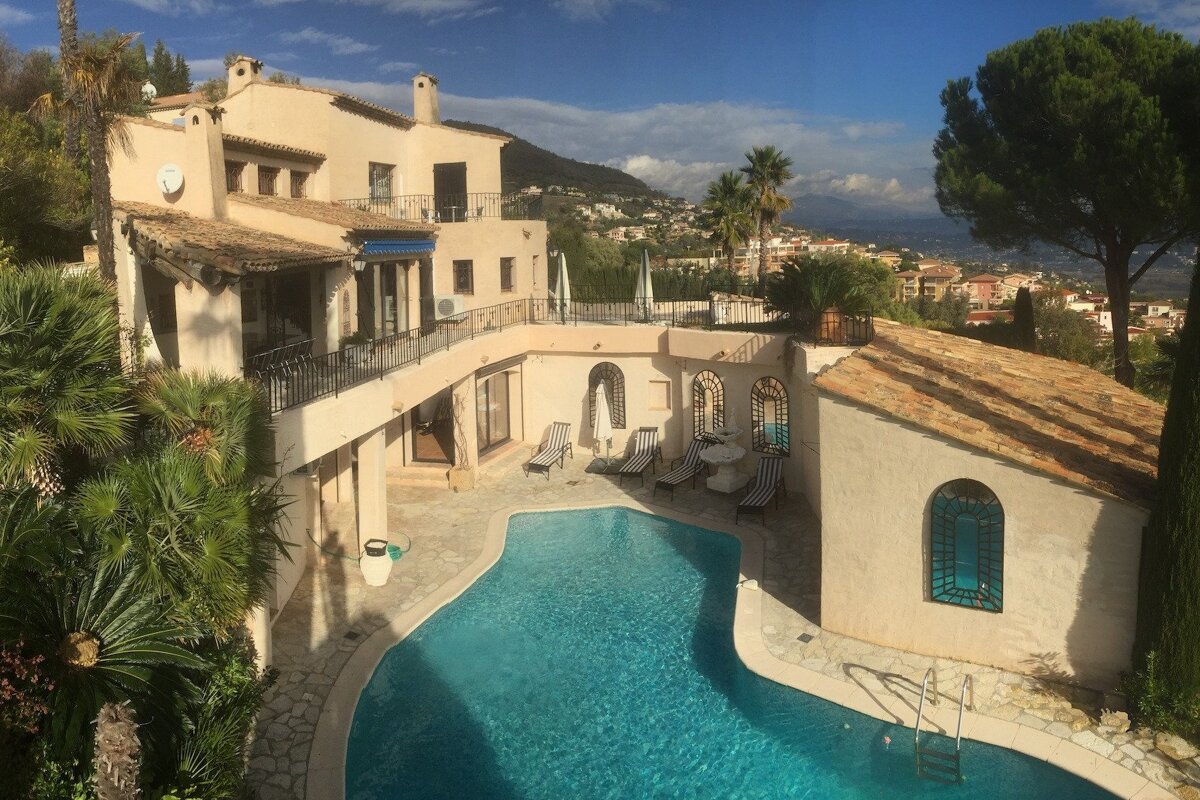 A large house with a swimming pool in front of it