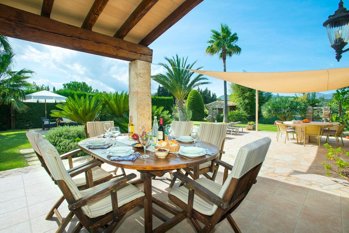 A patio with a table and chairs and a bottle of wine