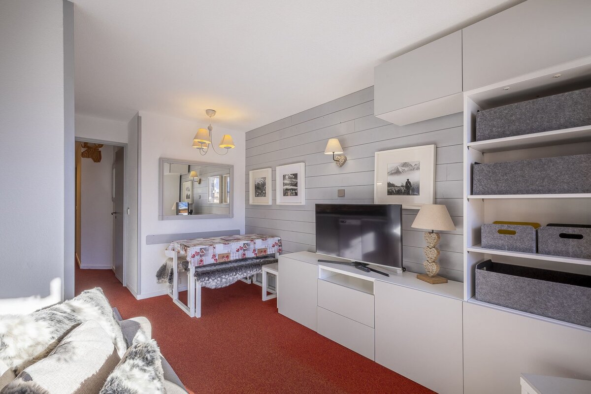 A living room with a table and a flat screen tv