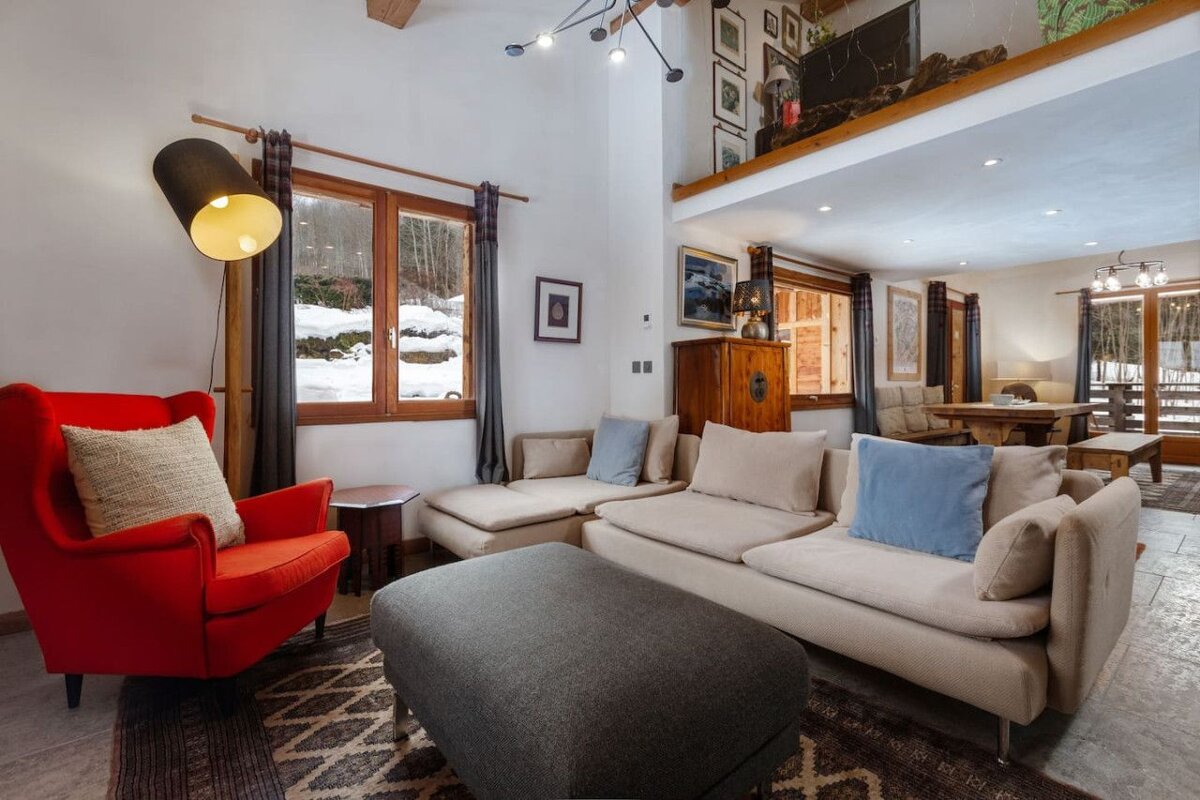 A living room with a red chair and a couch